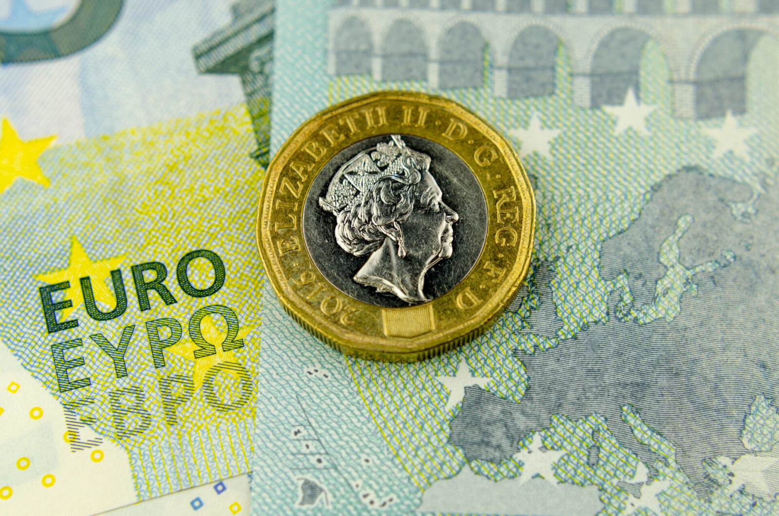 One pound sits next to euro banknotes