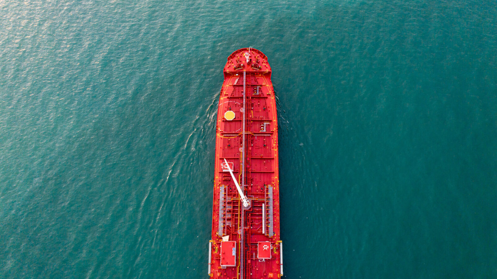 Aerial view of a red oil tanker under way in open water