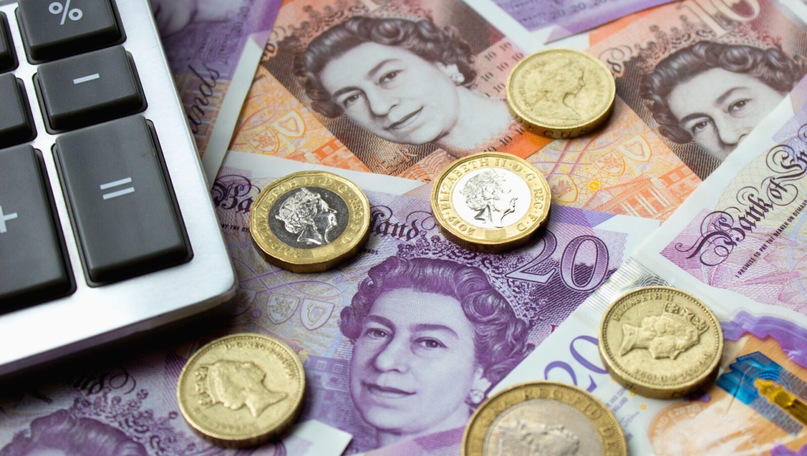 British pound banknotes and coins beside a calculator, representing sterling and UK currency movements.