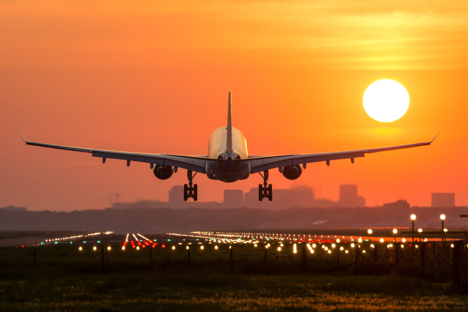 A plane lands at sunest